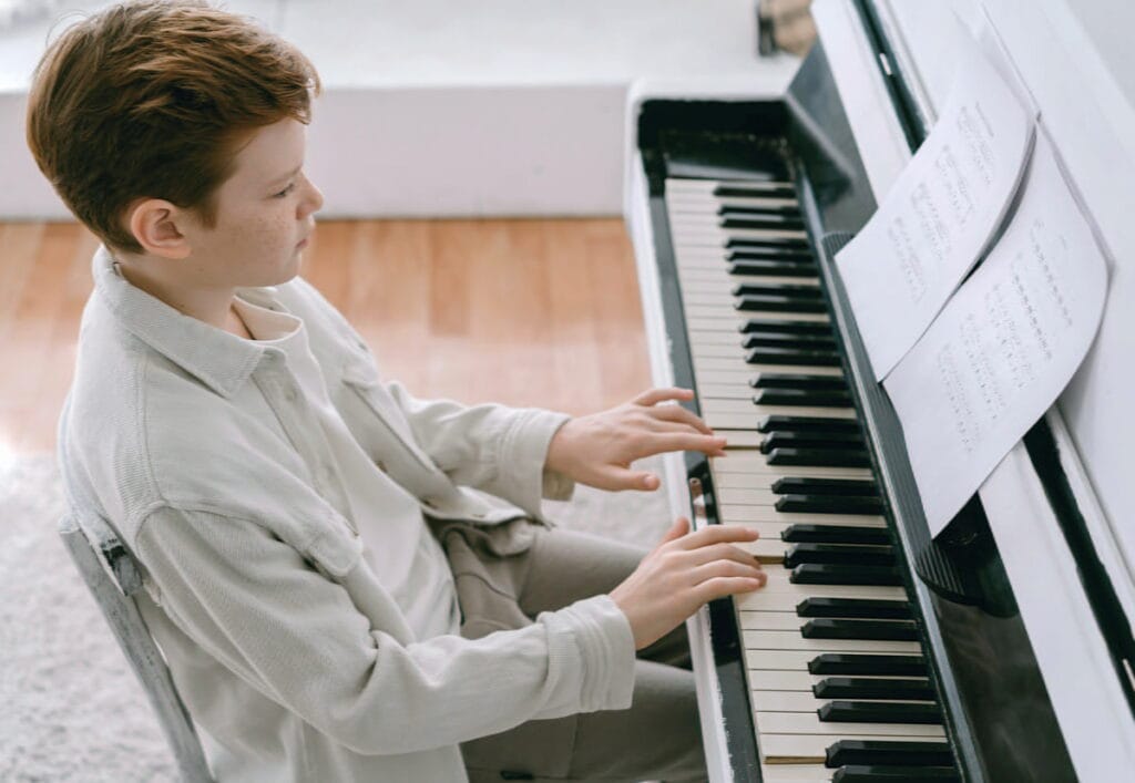Adolescent apprenant le piano à domicile dans une pièce lumineuse