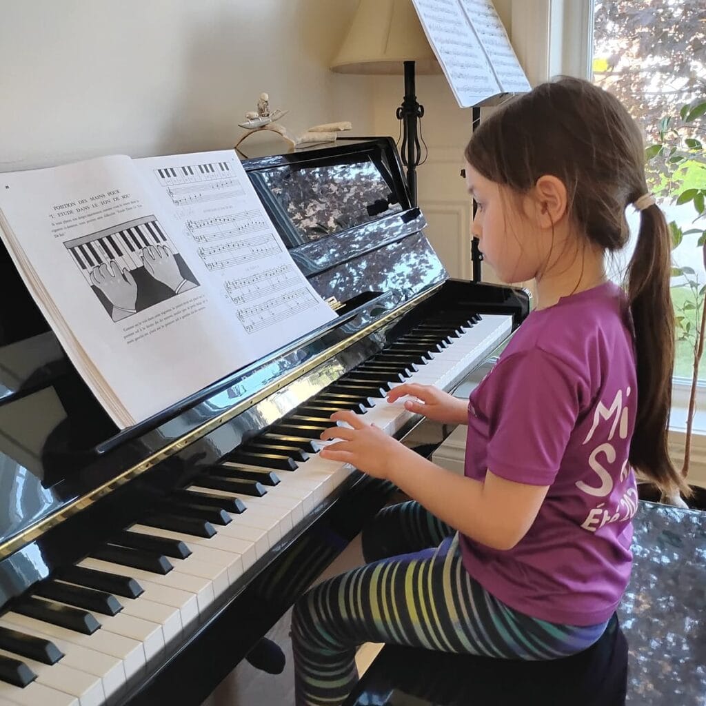 Enfant pratiquant le piano à domicile pendant un cours de musique