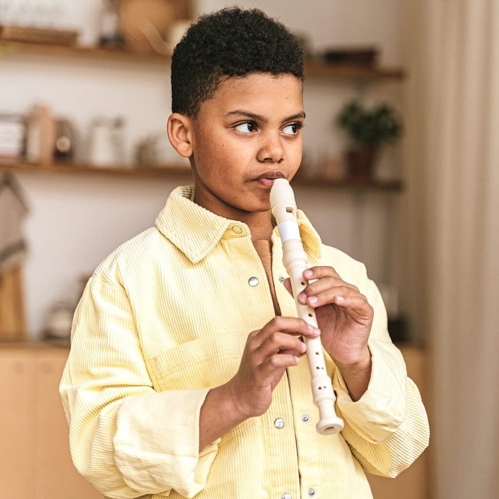 Enfant pratiquant la flûte à bec lors d’un cours de musique à domicile
