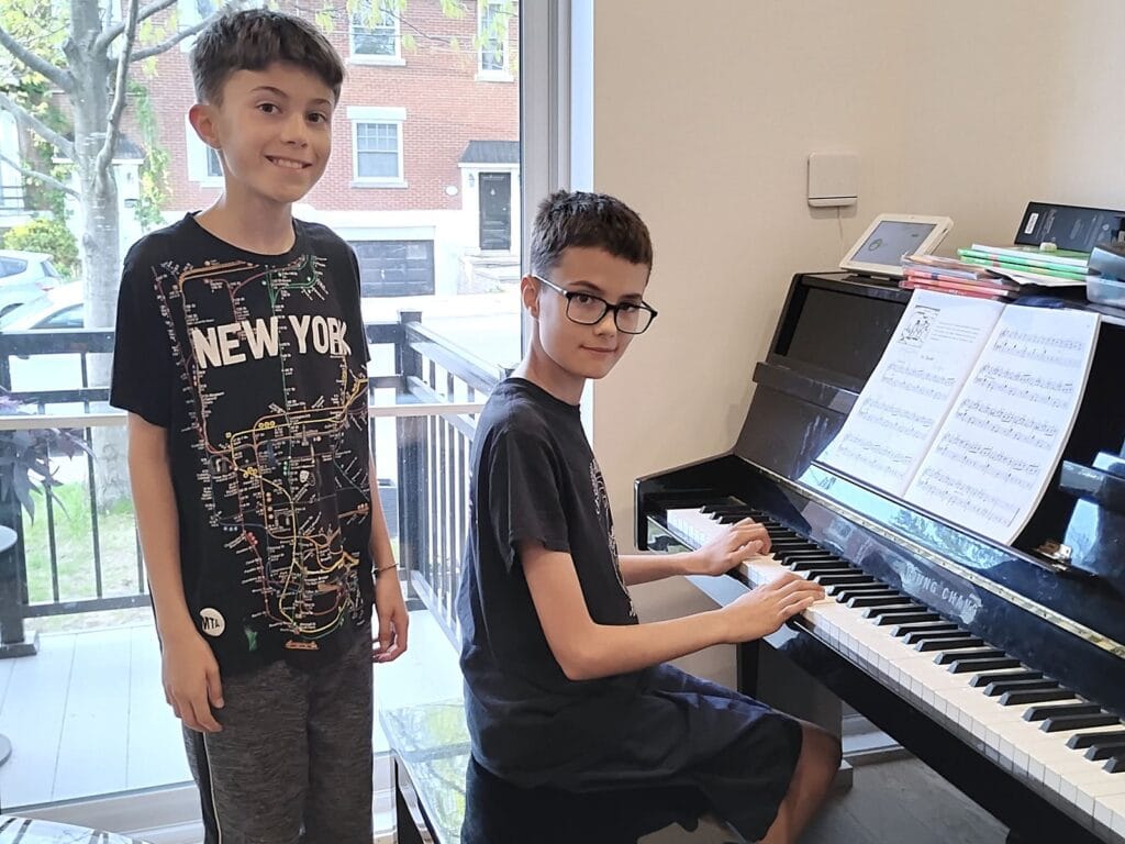 Deux enfants pendant un cours de piano à domicile