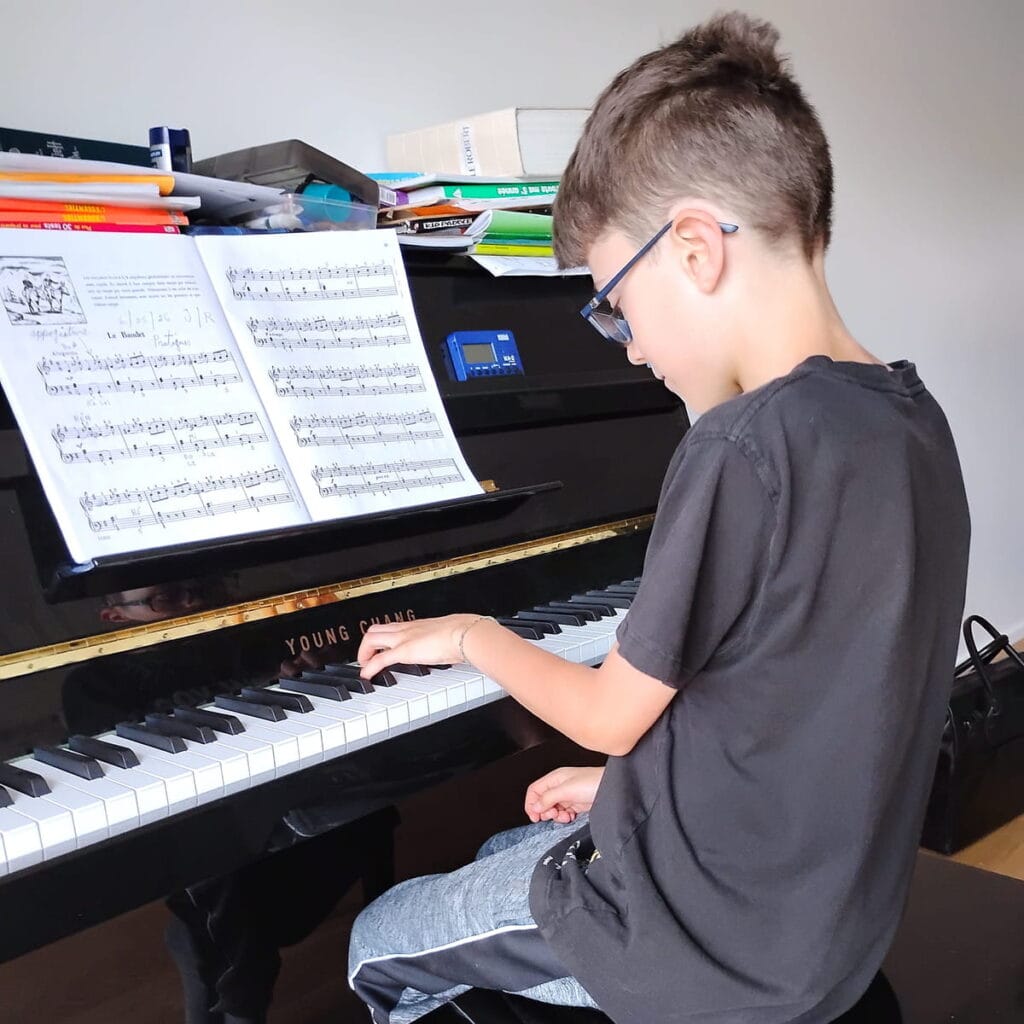 Enfant qui pratique le piano à domicile pendant un cours de musique