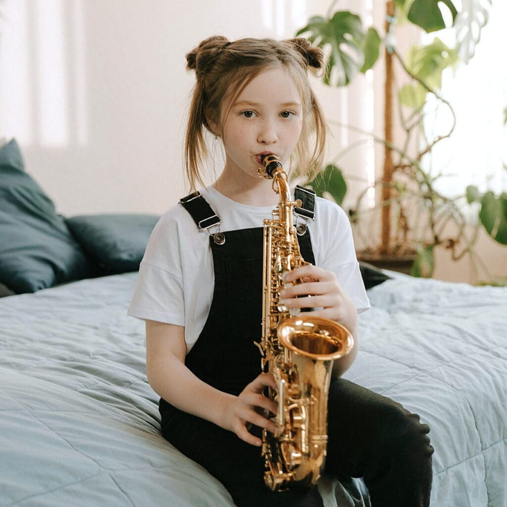 Enfant pratiquant le saxophone à domicile pendant un cours de musique
