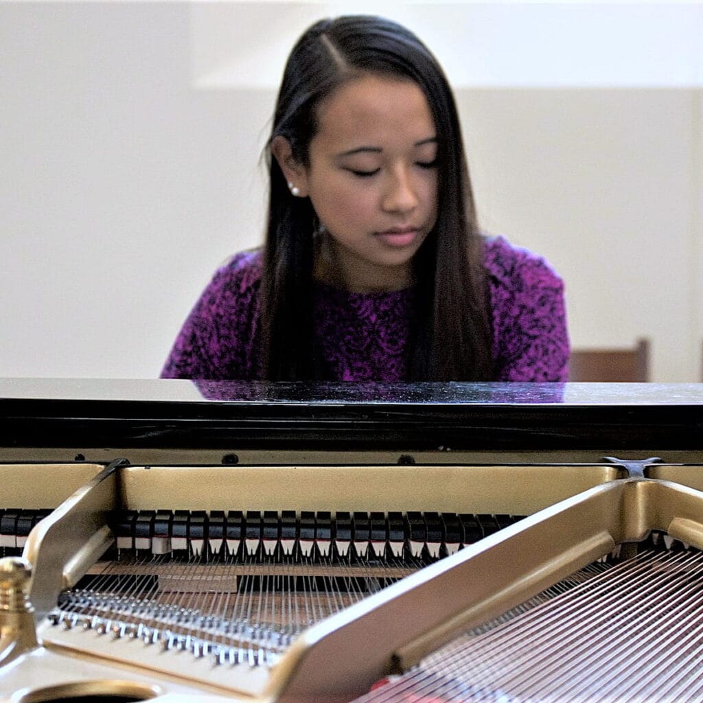 Adulte qui pratique le piano à domicile dans un environnement calme et lumineux.