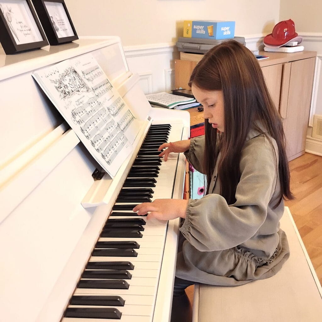Enfant qui pratique le piano à domicile pendant un cours de piano à Montréal.