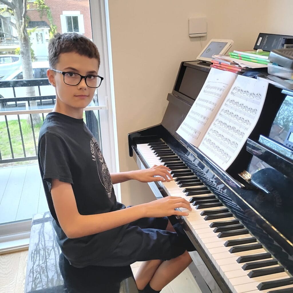 Jeune élève jouant du piano à domicile lors d'un cours à Montréal.